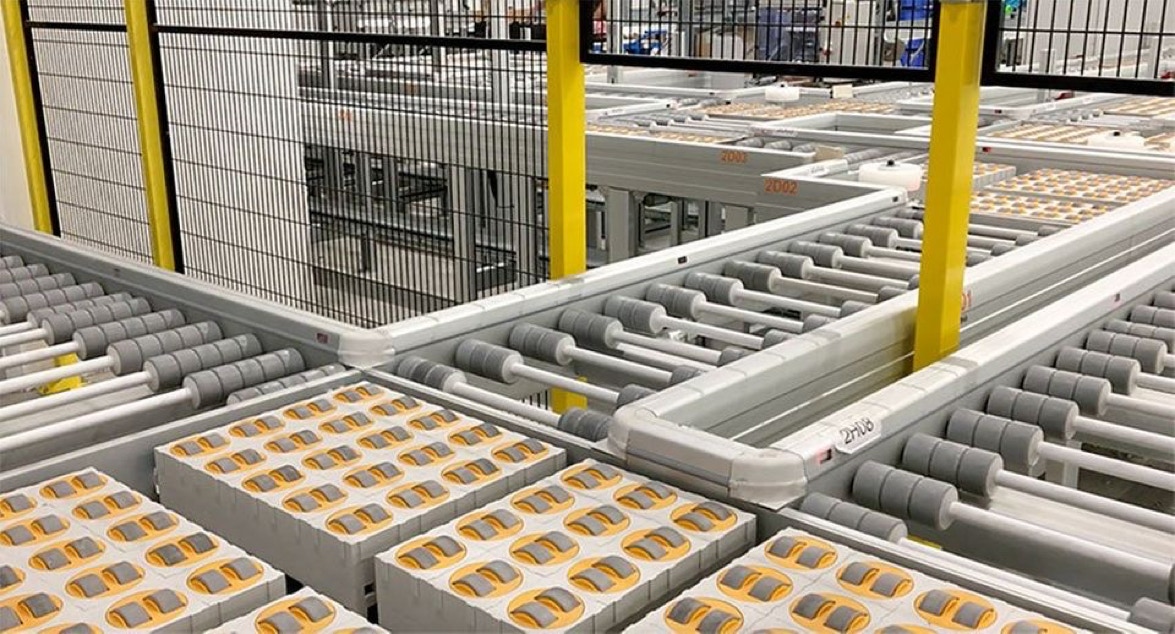 Logistikverteilsystem, Lager- und Logistiksystem, Großverteilerfläche vor einem Hochregallager, automatisierte Logistik, Lagerlogistik, integrierte Logistik, Kisten- und Kartonfördertechnik